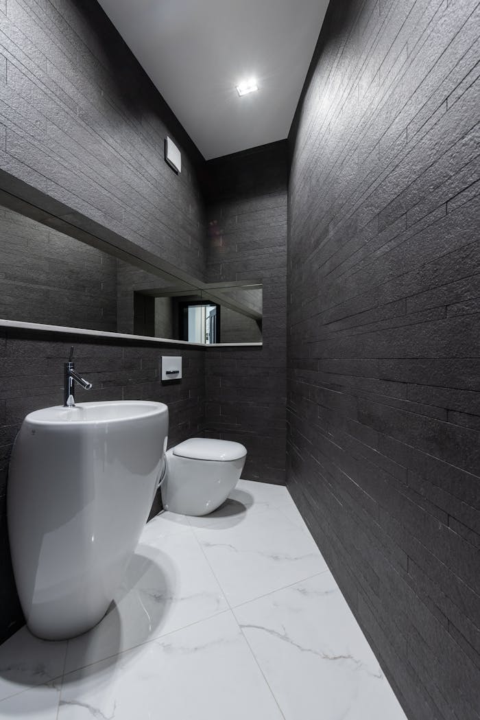 services-03 Interior of modern bathroom with creative white sink and toilet and dark gray walls