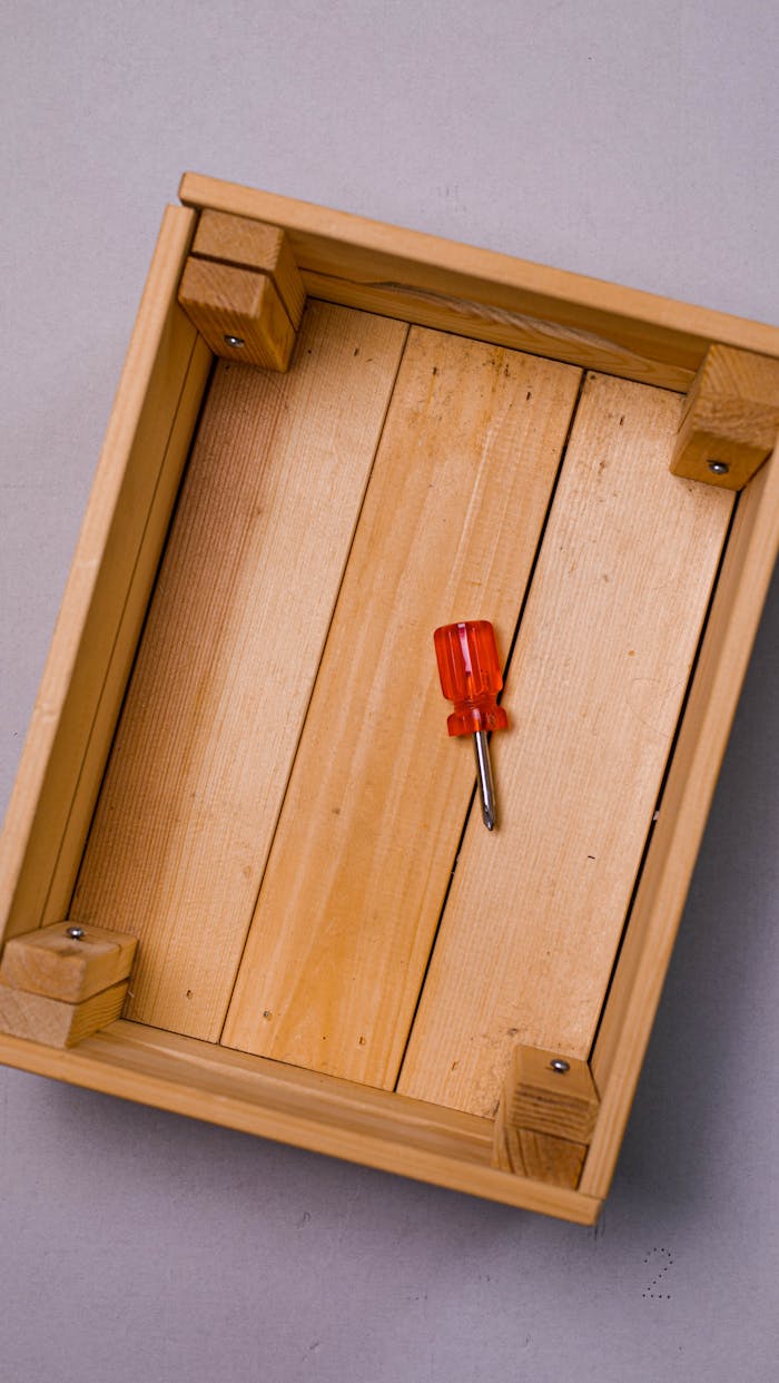 gallery-5 Top view of a wooden box with red screwdriver on a purple surface, perfect for DIY themes.